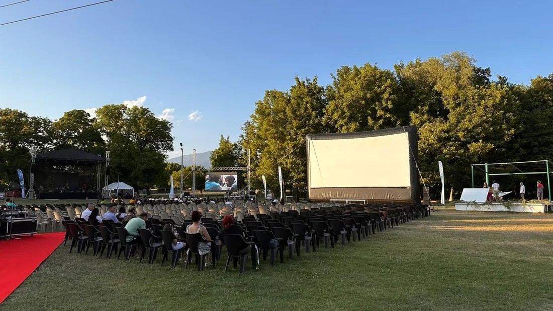 Scaune pregătite în fața ecranului de cinema în aer liber, ziua