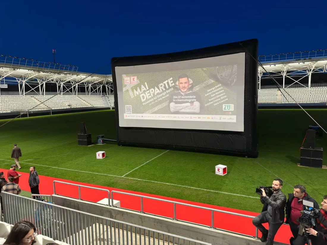 Ecran gonflabil de cinema montat pe un stadion, seara